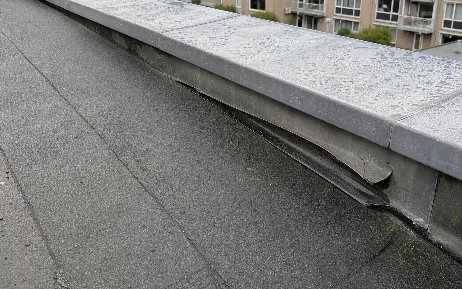 Detailfoto van los en vervormd loodwerk bij dakopstand