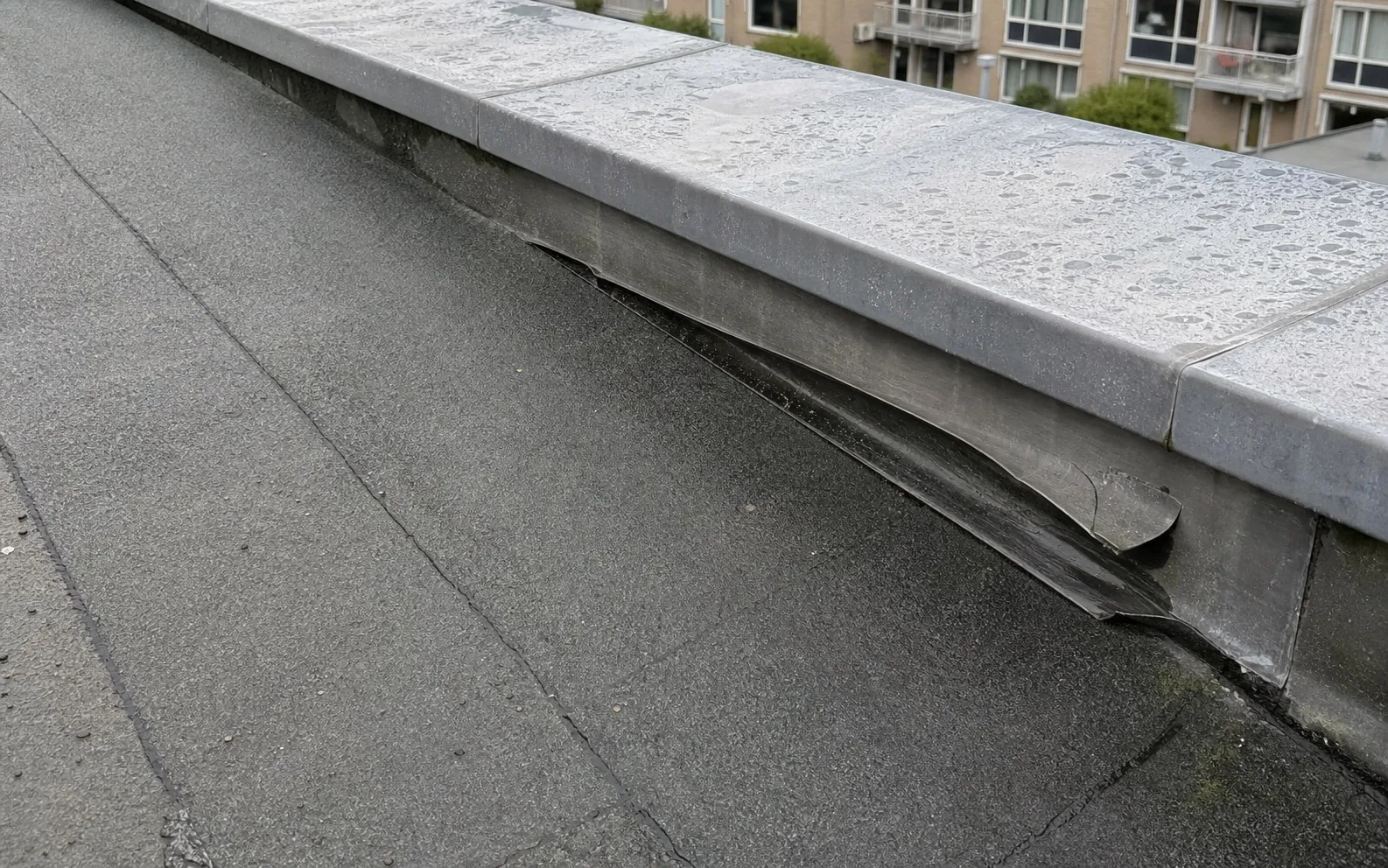 Detailfoto van los en vervormd loodwerk bij dakopstand